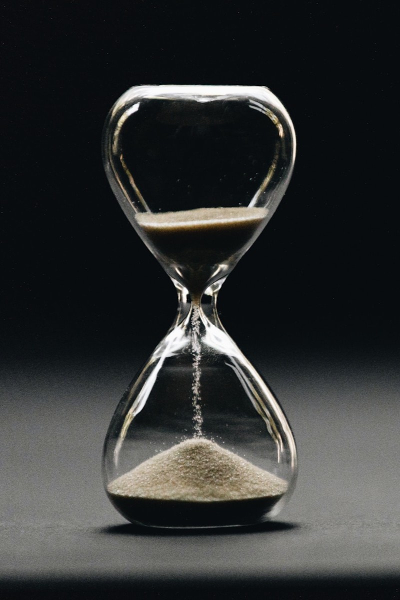 a black and white photo of a clock in the dark